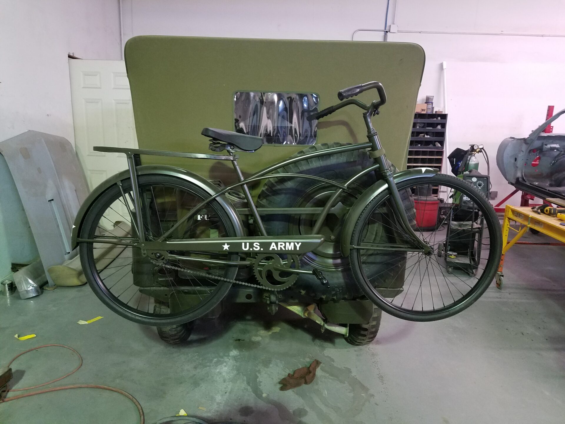 A bike attached behind the 1953 Military Jeep