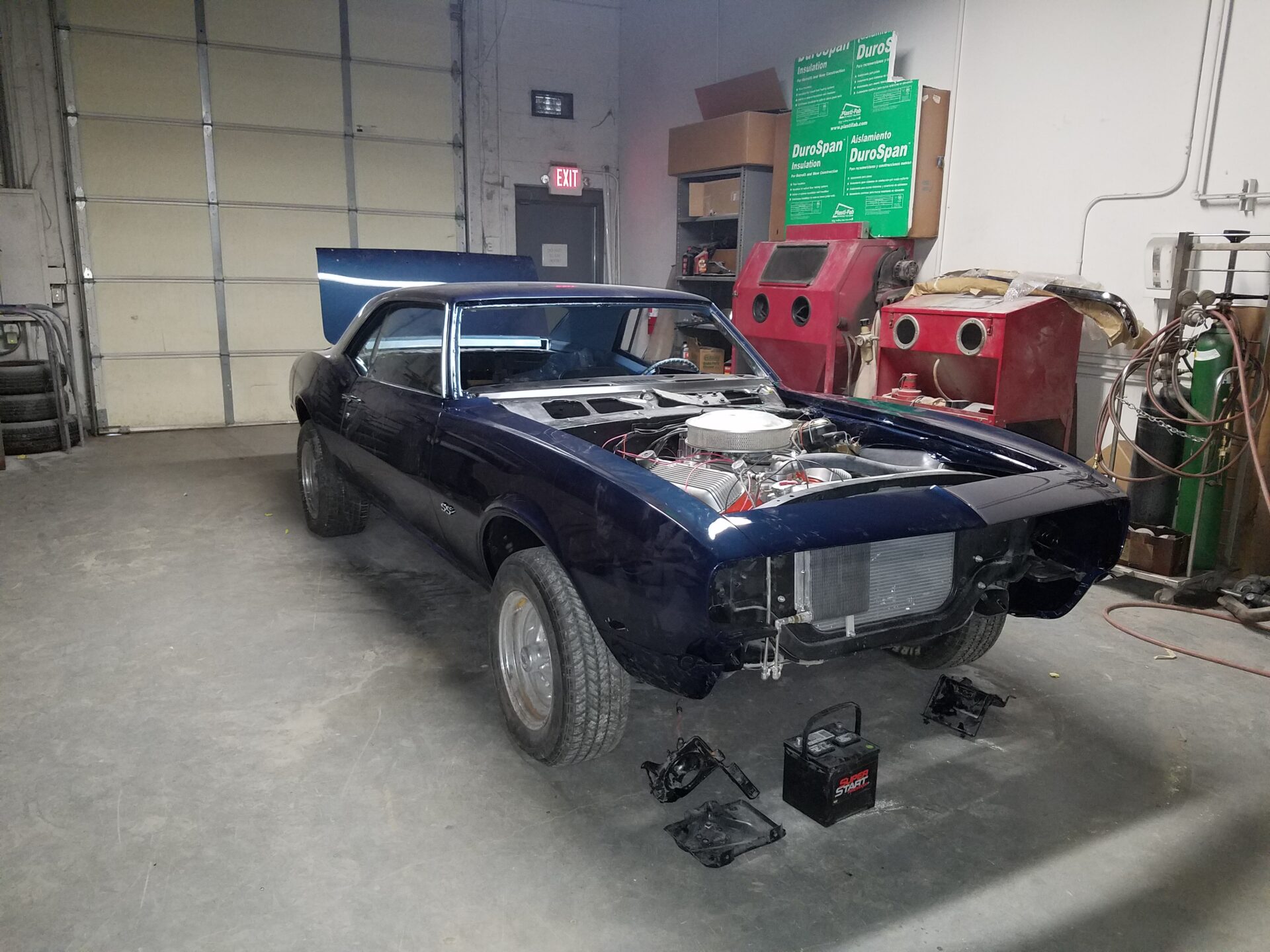A dark blue 1968 Chevy Camaro SS without a hood
